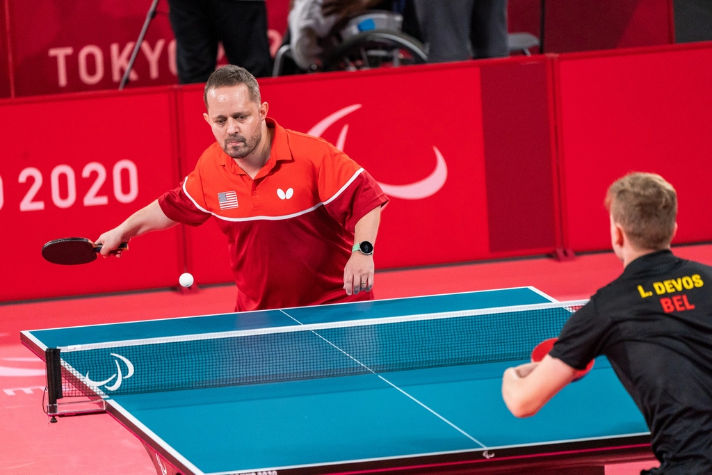 Athletes compete table tennis match