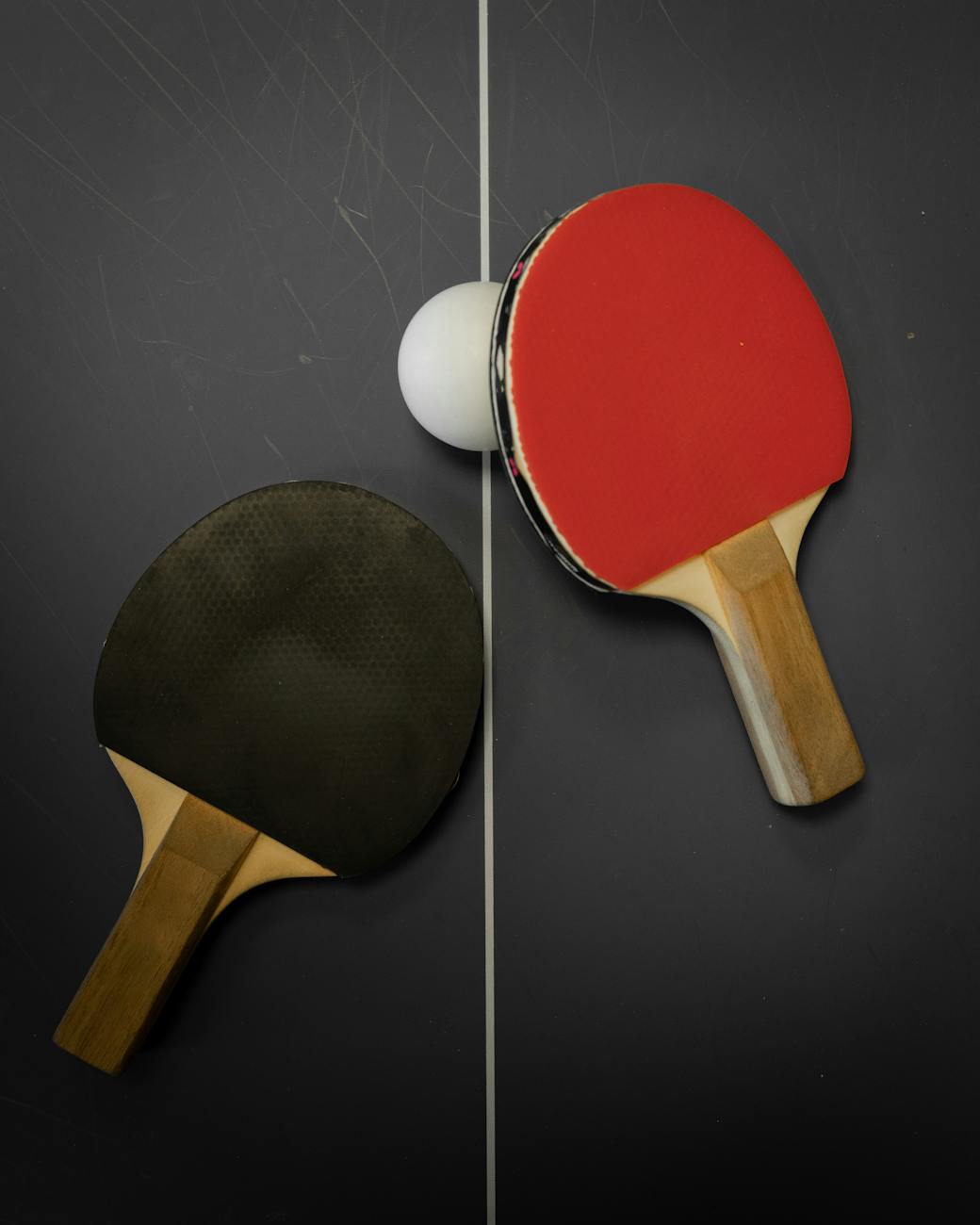 photograph of table tennis rackets and a white ball